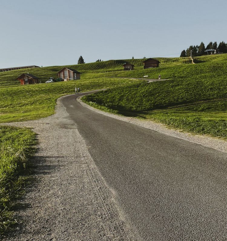 carretera asfaltada y campos verdes alrededor alpe siusi